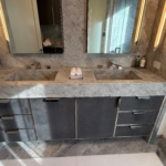 Custom polished stainless-steel frames and leather wrapped bathroom vanity. This piece has integrated hardware as well